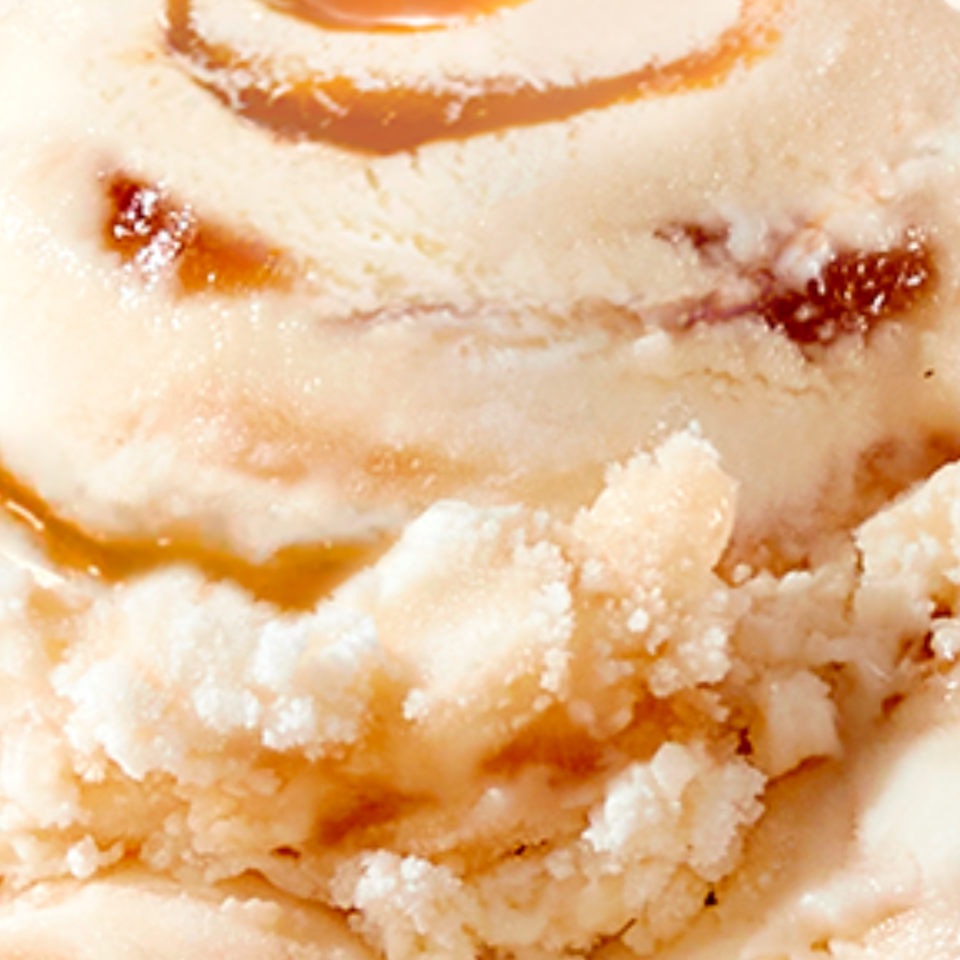 Extreme close-up texture shot of N!CK'S Sea Salt Caramel light ice cream, showing swirls of caramel and the creamy texture of the light ice cream base.