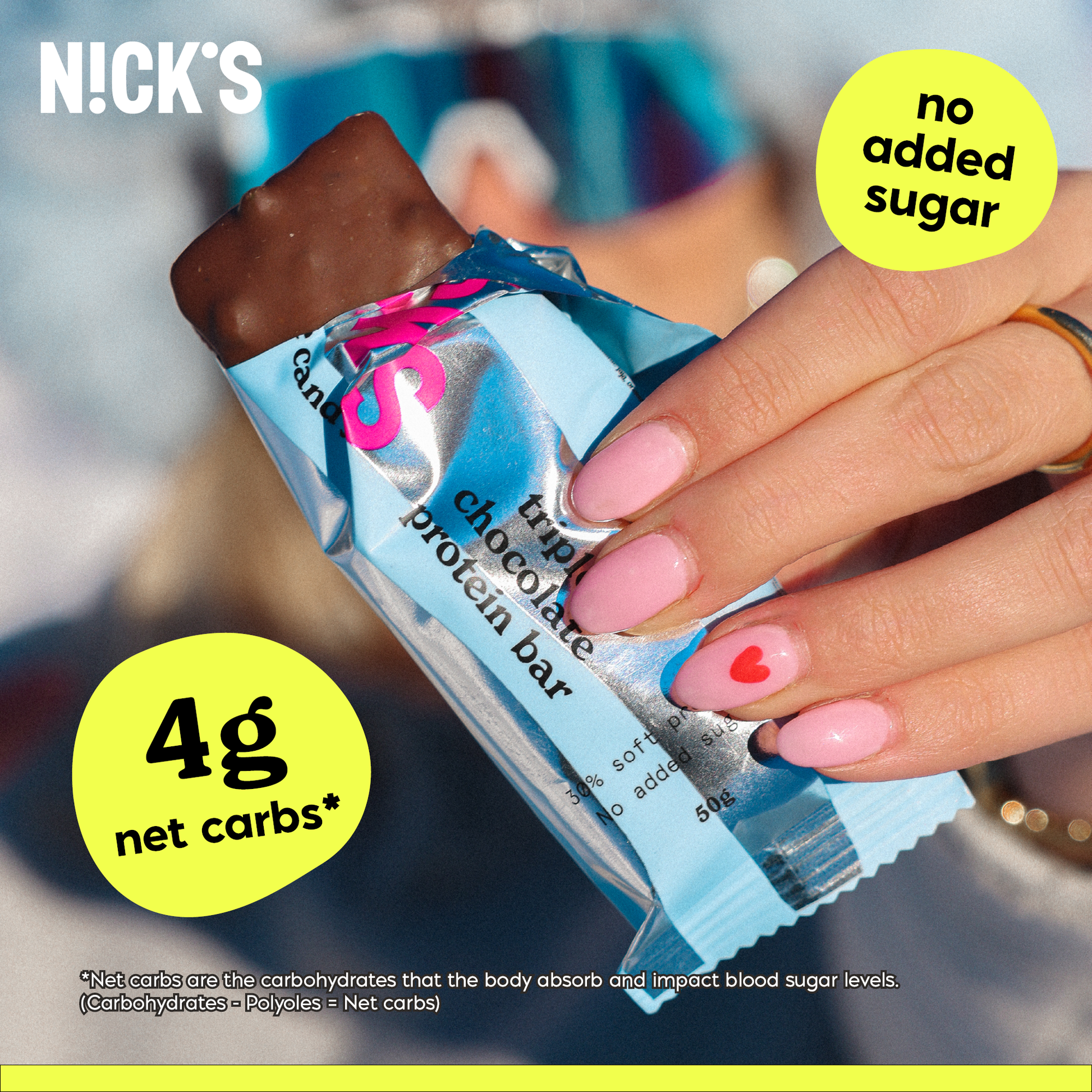 Close-up of a hand with pink heart-painted nails holding a N!CK'S Triple Chocolate Protein Bar. Text highlights '4g net carbs*' and 'no added sugar' for the low-carb protein snack.